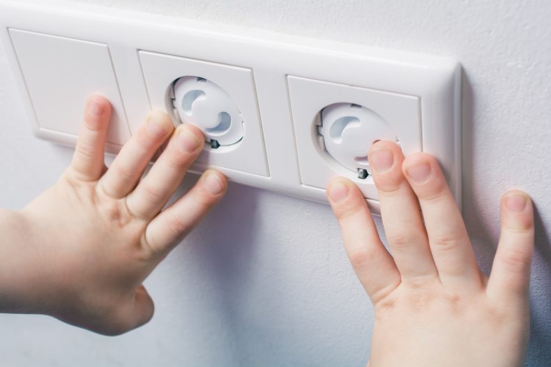 Proteja tomadas com tampas, fita isolante ou mesmo móveis. Foto: Getty Images.